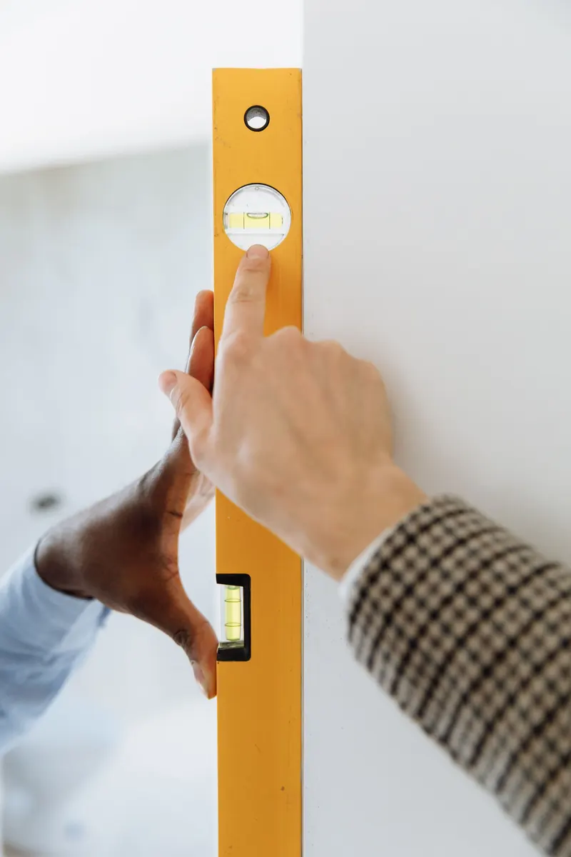 Checking a wall with a spirit level during mobile home releveling